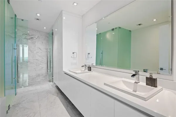a bathroom with a double vanity sink mirror and shower