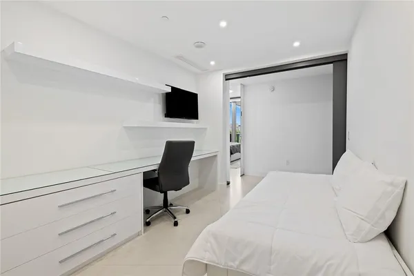 a bedroom with a bed and a flat screen tv