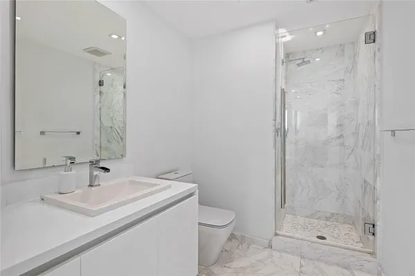 a bathroom with a sink a toilet and shower