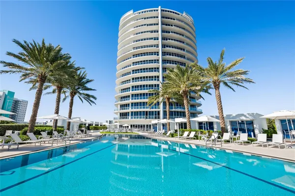 a front view of multi story residential apartment building with yard and swimming pool