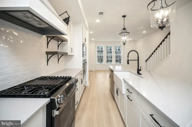 a kitchen with sink stove and refrigerator