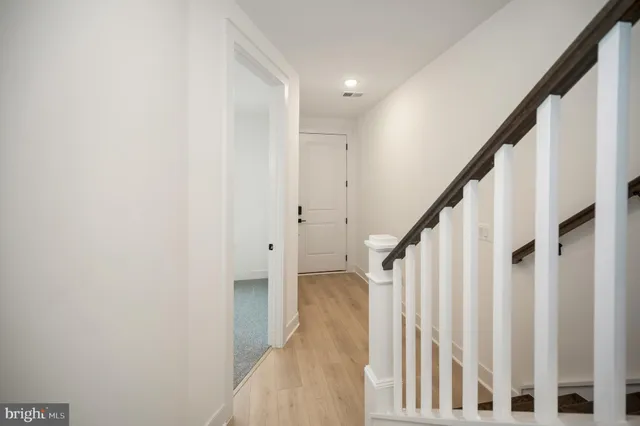 a view of staircase with railing and white walls