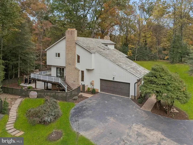 an aerial view of a house with swimming pool and outdoor seating