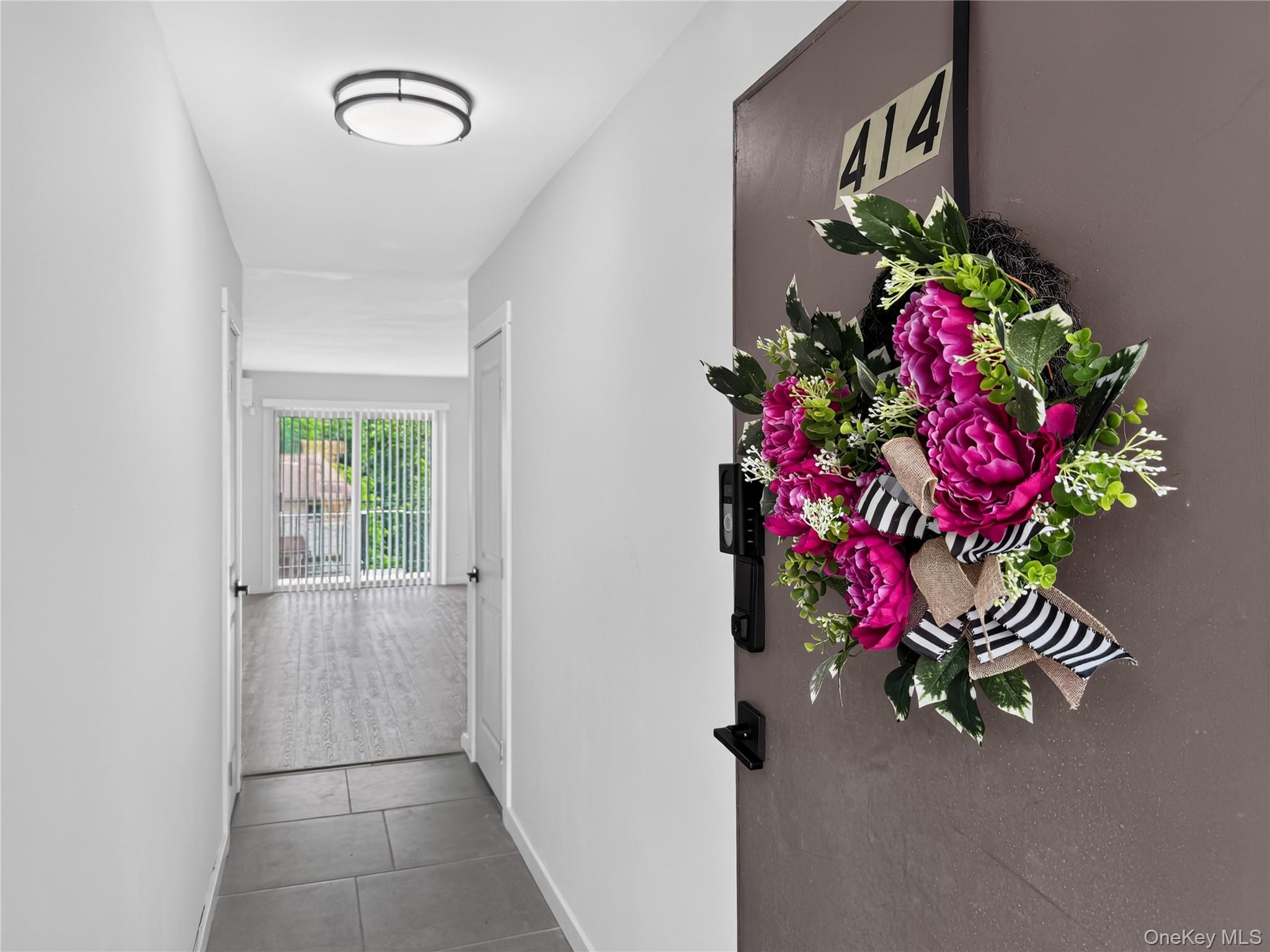 26 Cooper Road, Unit 414 Poughkeepsie, NY 12603 - Photo 4 of 24 Entryway featuring large format tile flooring, a modern flush mount ceiling light, and a white interior door