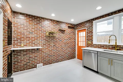 a bathroom with a granite countertop sink a toilet a mirror and shower