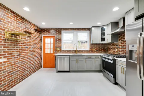 a large kitchen with granite countertop a sink and a stove