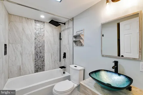 a bathroom with a tub toilet sink and mirror