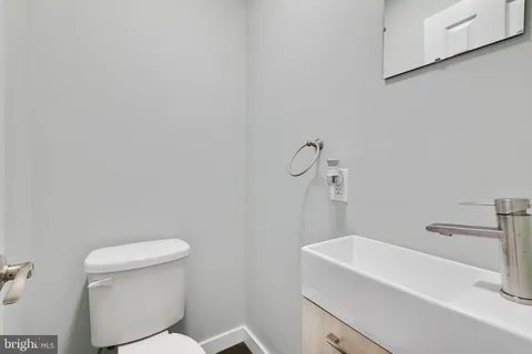 a bathroom with a sink a toilet and a mirror