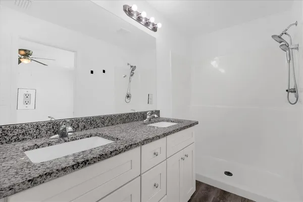 a bathroom with a granite countertop sink and a mirror