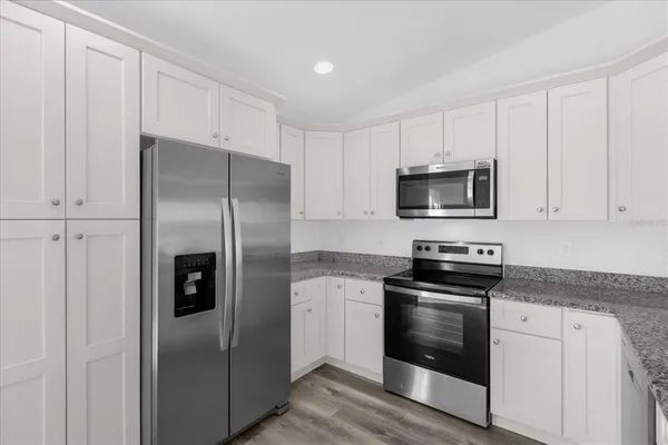 a kitchen with white cabinets and stainless steel appliances