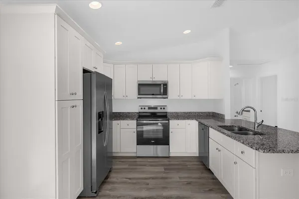 a kitchen with stainless steel appliances granite countertop a refrigerator and a stove top oven