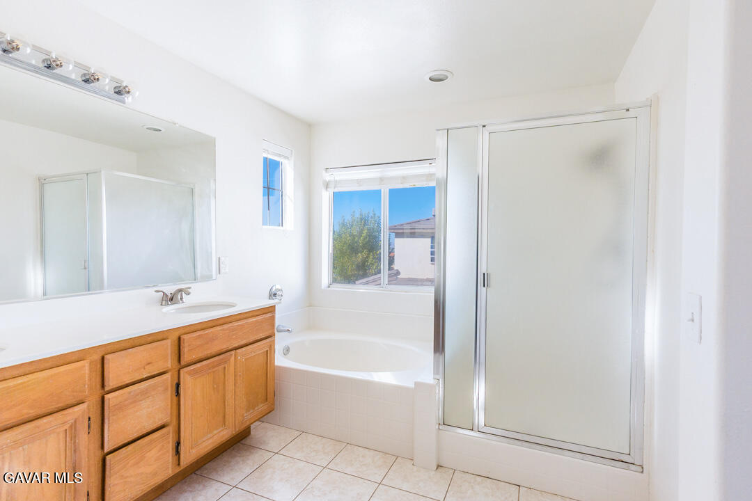 38318 Wakefield Place Palmdale, CA 93551 - Photo 22 of 33 a bathroom with a tub sink and mirror