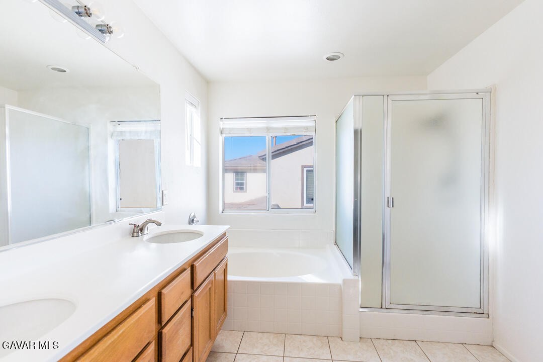 38318 Wakefield Place Palmdale, CA 93551 - Photo 23 of 33 a bathroom with a bathtub sink and mirror