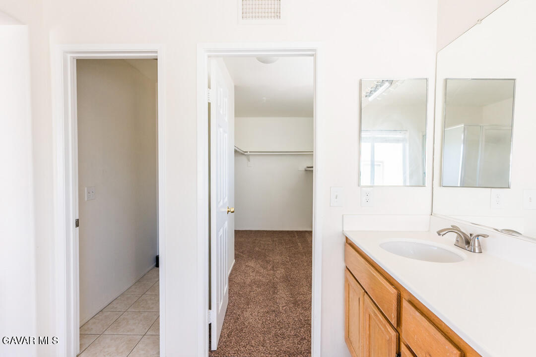 38318 Wakefield Place Palmdale, CA 93551 - Photo 24 of 33 a bathroom with a sink and a mirror