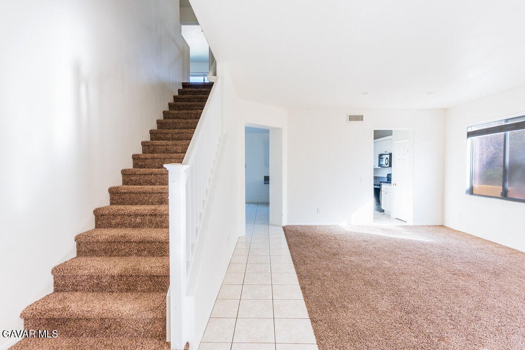 38318 Wakefield Place Palmdale, CA 93551 - Photo 5 of 33 a view of a hallway with stairs and a chandelier