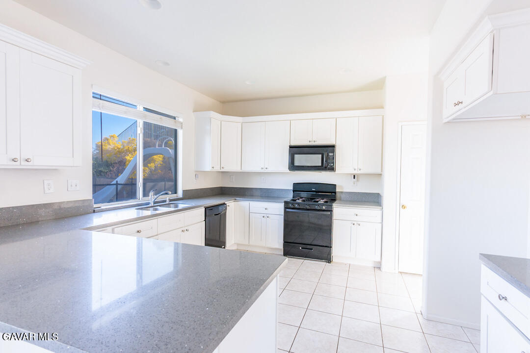 38318 Wakefield Place Palmdale, CA 93551 - Photo 8 of 33 a kitchen with stainless steel appliances granite countertop a stove top oven a sink and a refrigerator