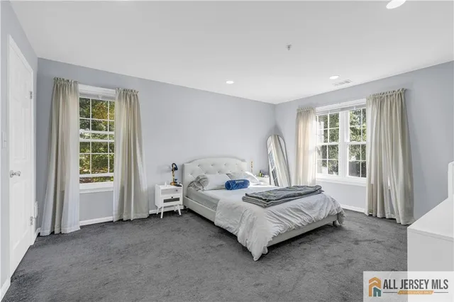 a spacious bedroom with a bed and a window