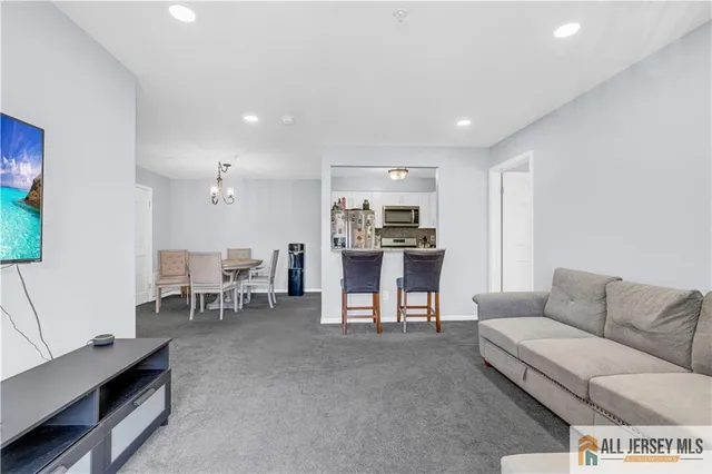 a living room with furniture and kitchen area