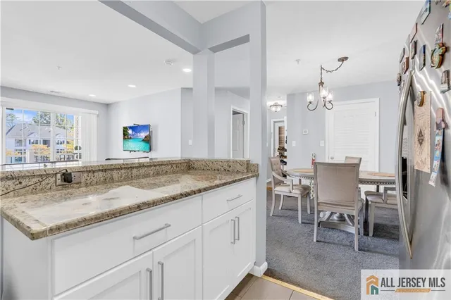 a bathroom with a granite countertop sink a window and chairs
