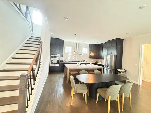 a kitchen with a table chairs sink and cabinets