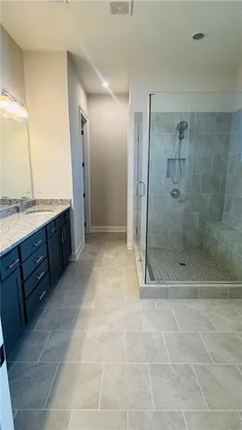 a bathroom with a granite countertop sink a mirror and a bathtub