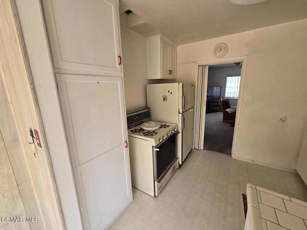 17526 Miranda Street Encino, CA 91316 - Photo 6 of 28 a view of a kitchen with refrigerator and white cabinets