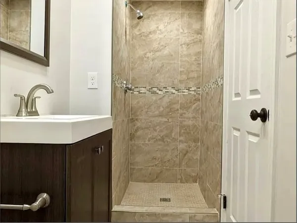 a bathroom with a sink mirror and shower
