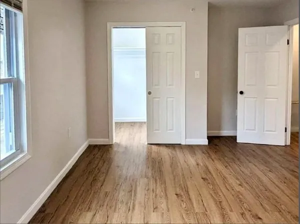 a view of a hallway with wooden floor and closet
