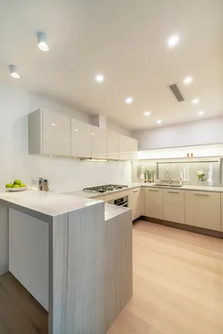 a kitchen with a sink a stove cabinets and counter top space