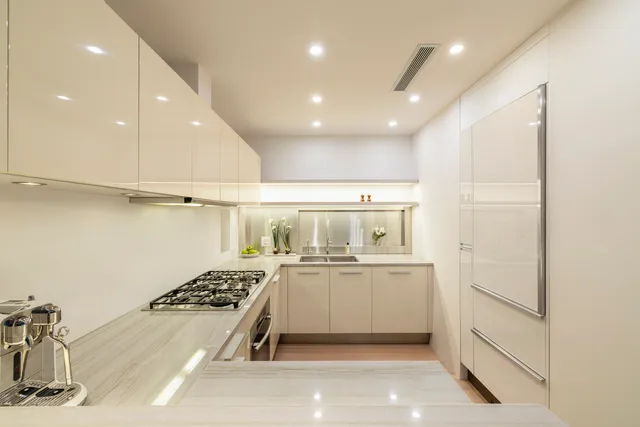 a kitchen with a sink stainless steel appliances and white cabinets