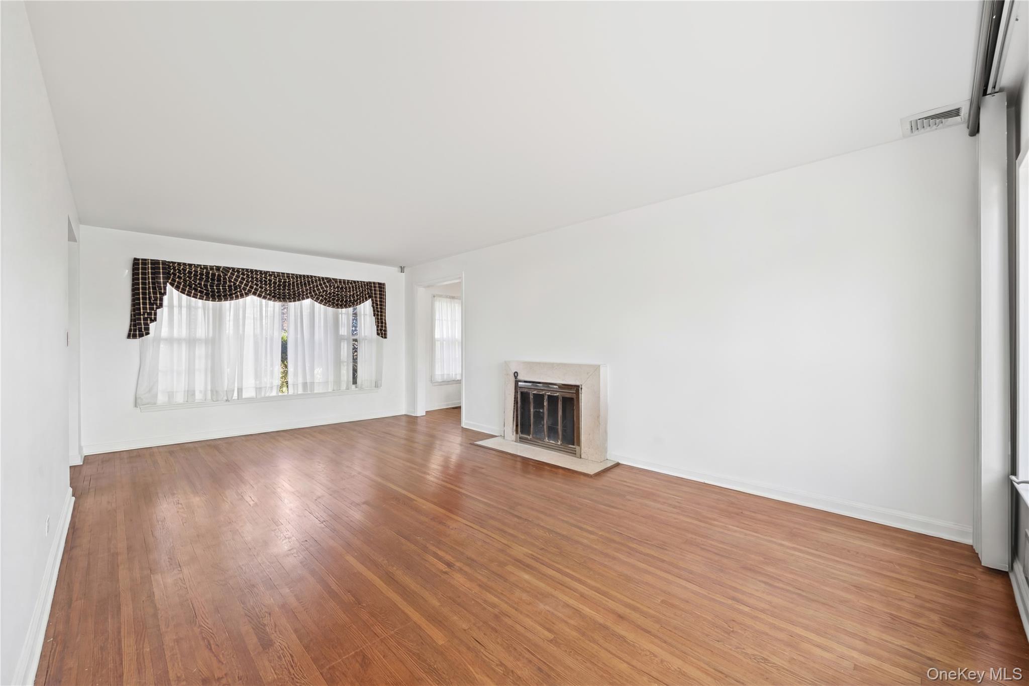 11 Searingtown Road Searingtown, NY 11507 - Photo 4 of 34 a view of a livingroom with wooden floor and a fireplace