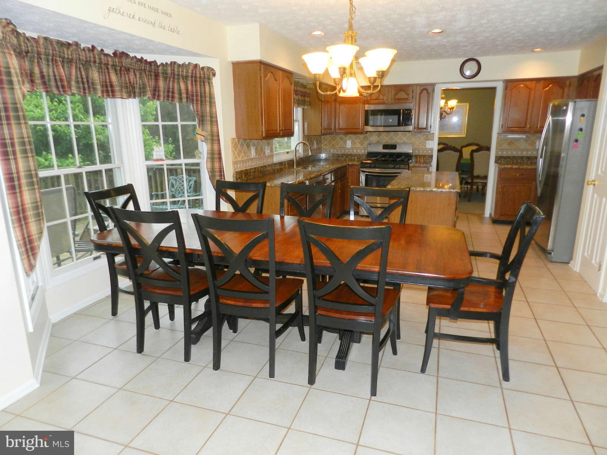 17224 Spates Hill Road Poolesville, MD 20837 - Photo 8 of 30 a view of a dining room with furniture a chandelier and large windows