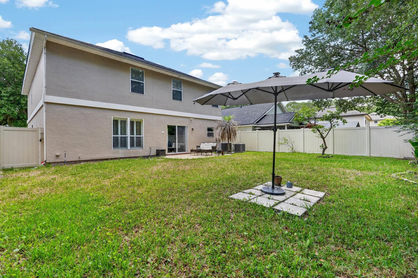 1237 Splendid Ravine Street St. Augustine, FL 32092 - Photo 32 of 62 a backyard of a house with table and chairs