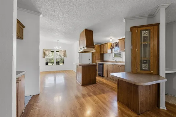 a kitchen with stainless steel appliances granite countertop a stove a sink dishwasher and a refrigerator with wooden floor