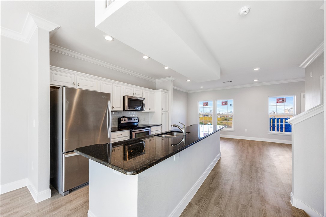 14814 Whitecap Boulevard Corpus Christi, TX 78418 - Photo 12 of 40 a kitchen with stainless steel appliances granite countertop a refrigerator a sink dishwasher a stove and a refrigerator with wooden floor