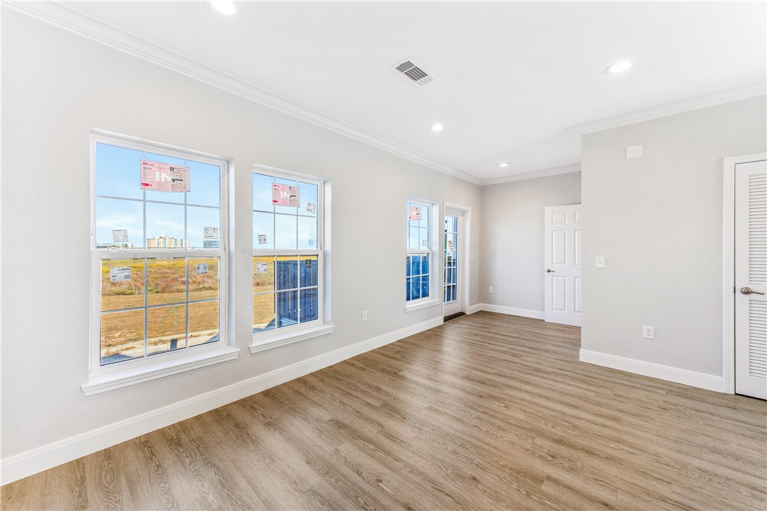 14814 Whitecap Boulevard Corpus Christi, TX 78418 - Photo 7 of 40 a view of an empty room with wooden floor and a window