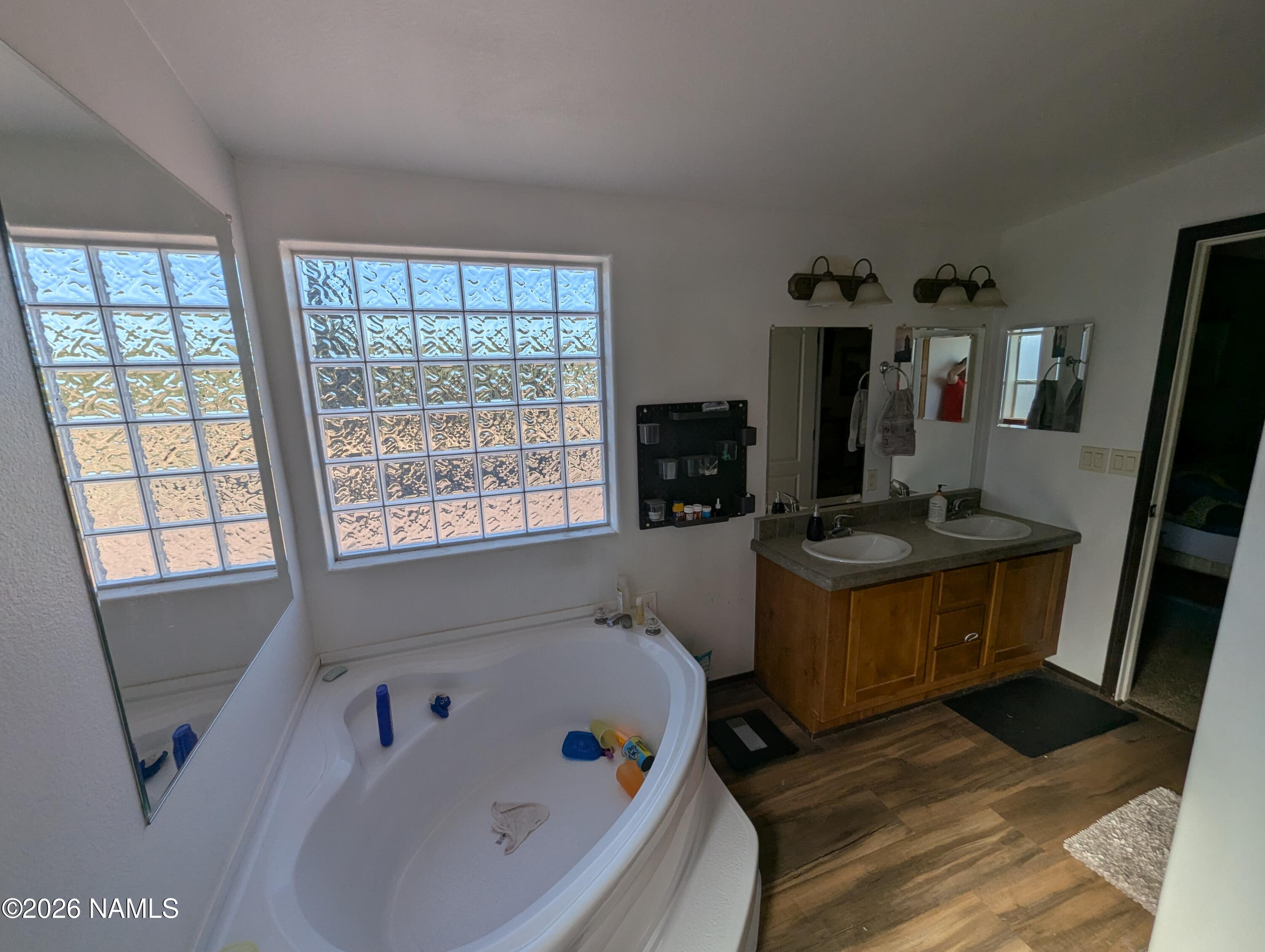 2186 East Clear Point Way Williams, AZ 86046 - Photo 17 of 43 a bathroom with a bathtub a sink and a window