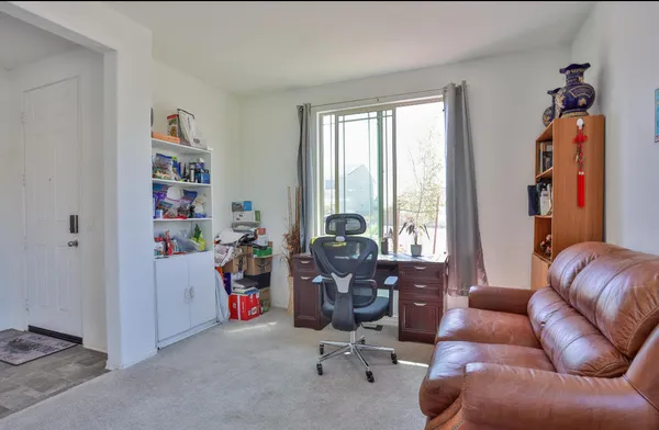 a view of a livingroom with workspace and a window