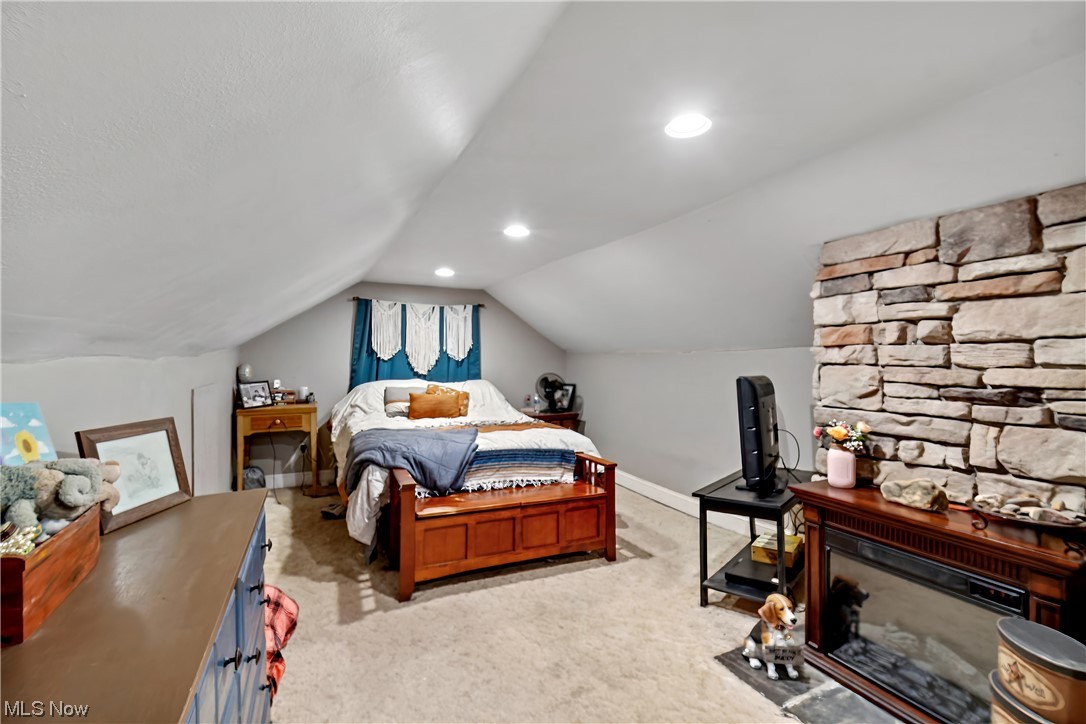 71300 Barton Road Bridgeport, OH 43912 - Photo 14 of 25 Carpeted bedroom featuring a stone fireplace and vaulted ceiling