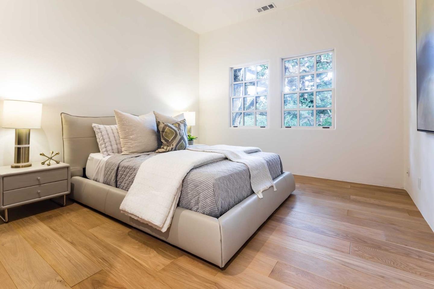 953 Roble Ridge Road Palo Alto, CA 94306 - Photo 39 of 50 a large bed sitting in a bedroom next to a lamp with a window and a lamp