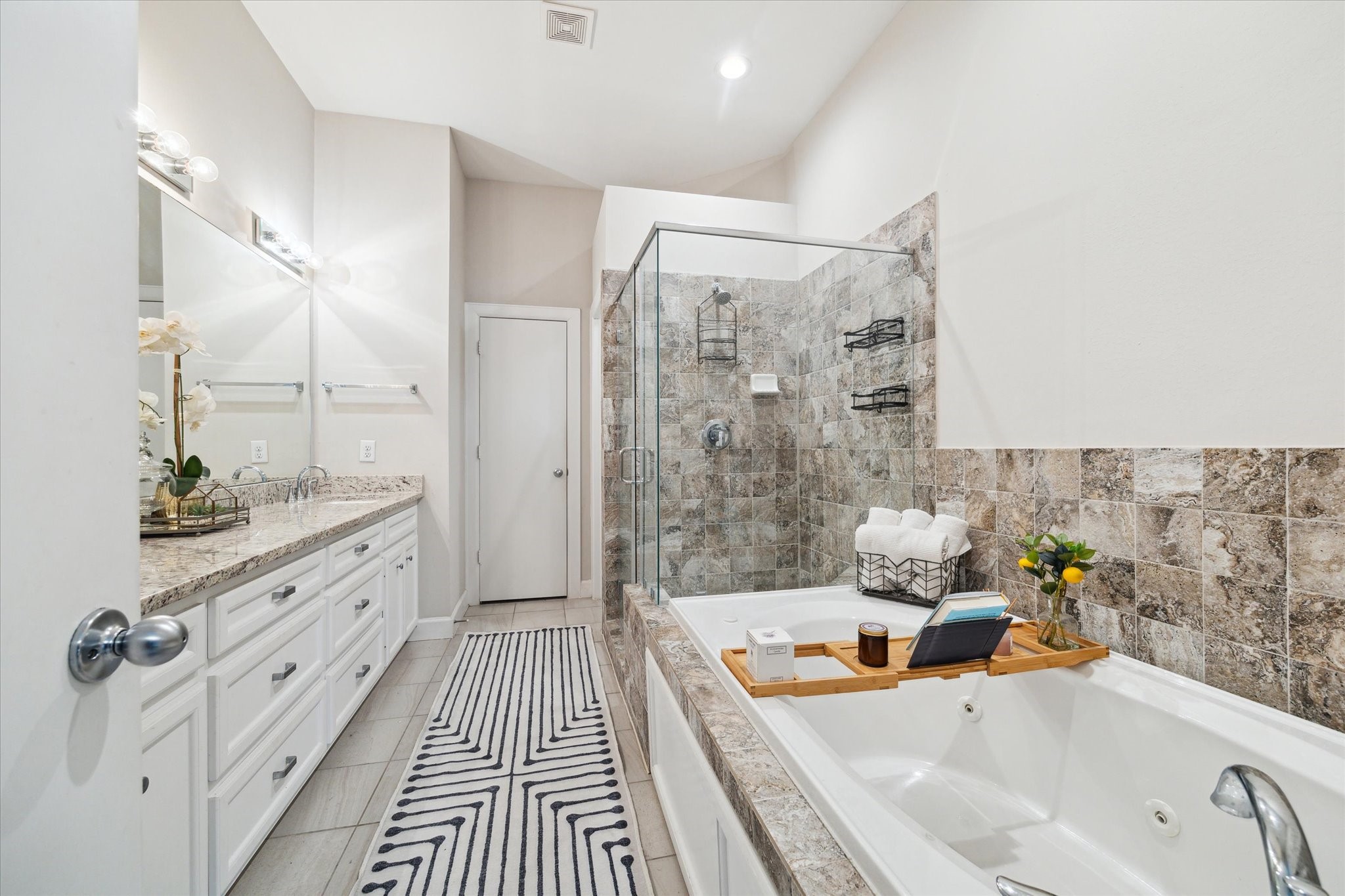 8705 Bryam Street, Unit 2003 Houston, TX 77061 - Photo 11 of 14 a spacious bathroom with a double vanity sink a large mirror a bathtub and shower