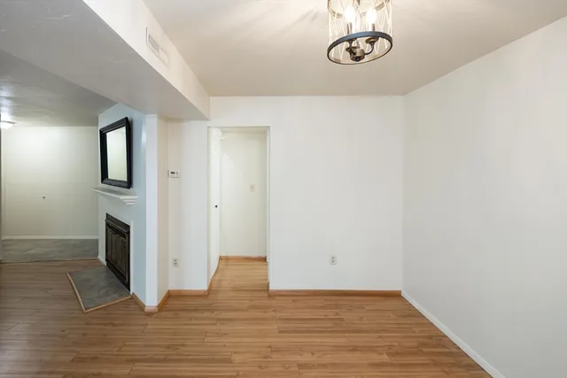 a view of a livingroom with wooden floor and washer dryer