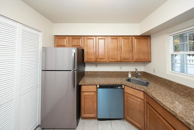 a kitchen with a refrigerator sink and cabinets