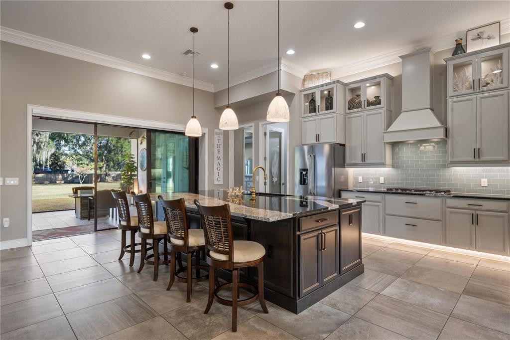 3738 Kissimmee Park Road St. Cloud, FL 34772 - Photo 16 of 62 a kitchen with stainless steel appliances granite countertop a stove a sink a oven a dining table and chairs