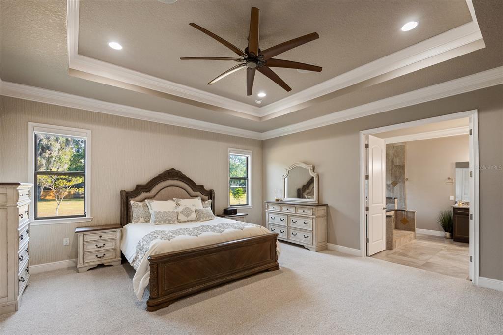 3738 Kissimmee Park Road St. Cloud, FL 34772 - Photo 27 of 62 a bedroom with a large bed a chandelier and closet