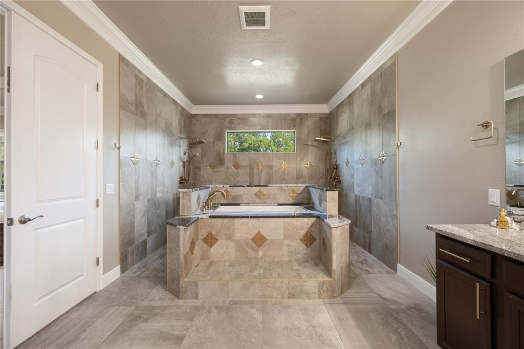 3738 Kissimmee Park Road St. Cloud, FL 34772 - Photo 36 of 62 a large bathroom with a granite countertop sink a toilet and shower