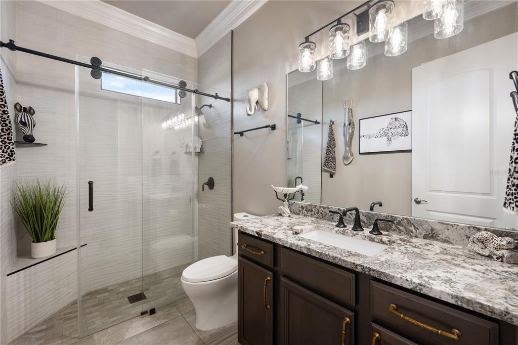 3738 Kissimmee Park Road St. Cloud, FL 34772 - Photo 40 of 62 a bathroom with a granite countertop sink a toilet a shower and a mirror