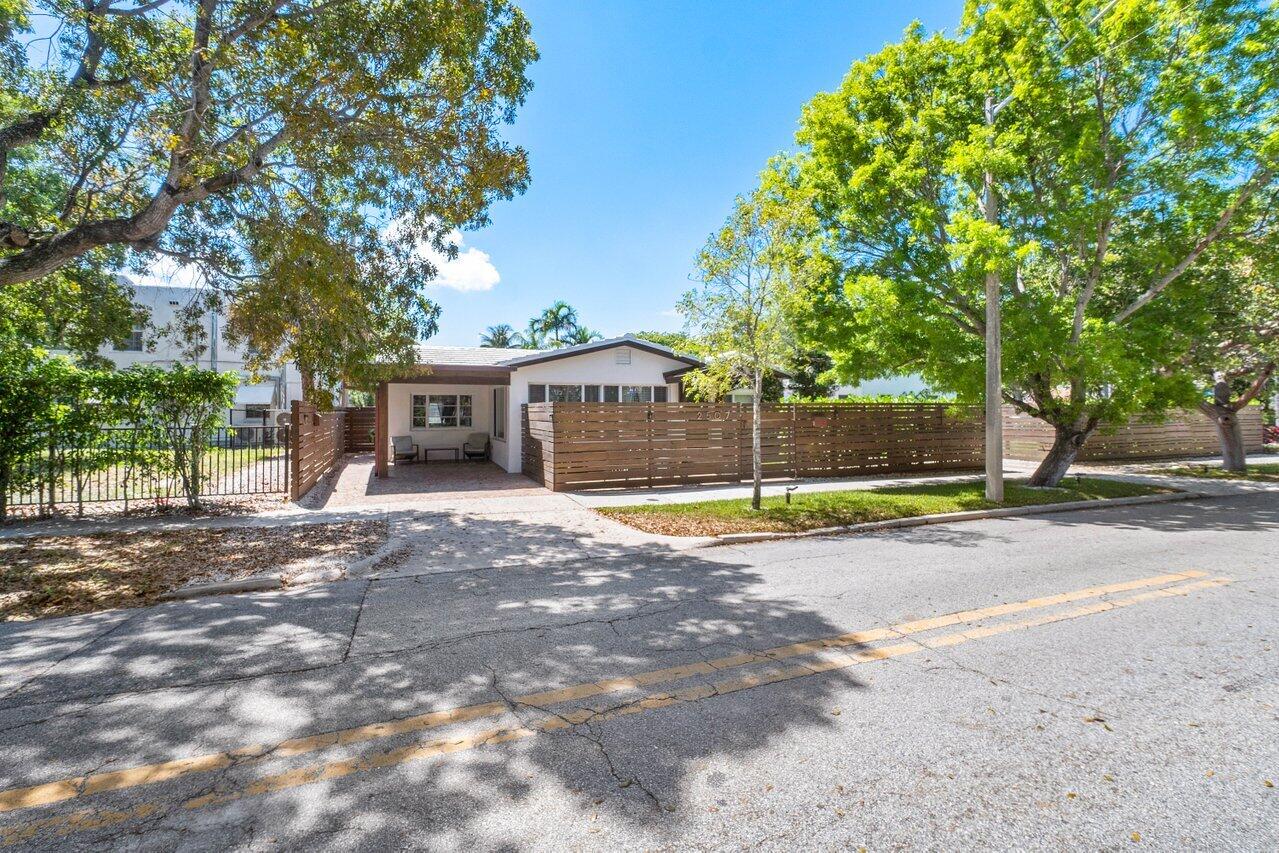 a view of a house with a yard and large tree