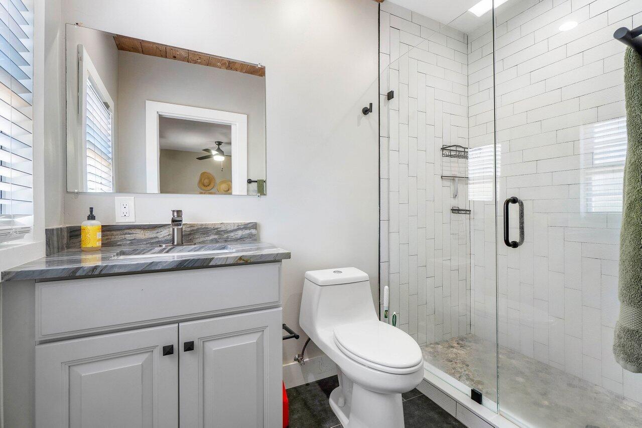 706 Sunset Road, Unit C West Palm Beach, FL 33401 - Photo 11 of 15 a bathroom with a granite countertop sink toilet and shower