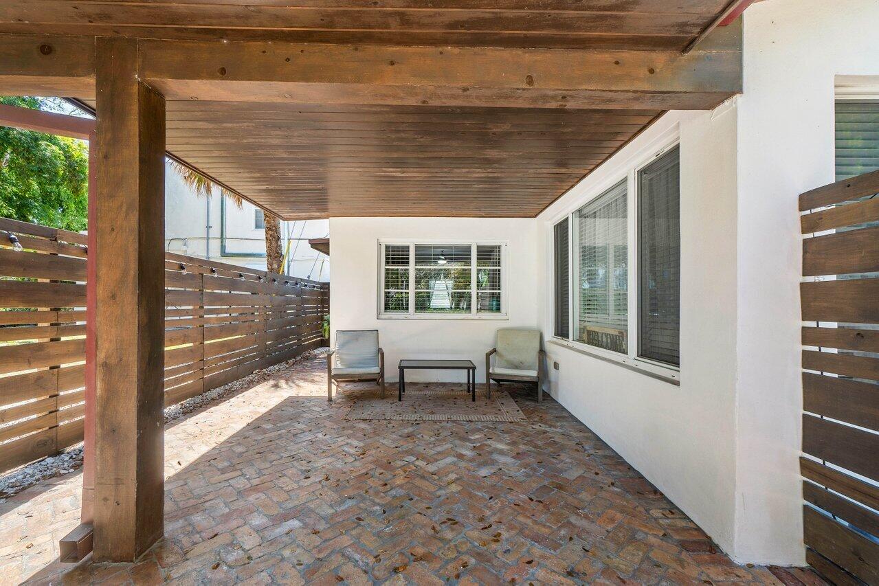 706 Sunset Road, Unit C West Palm Beach, FL 33401 - Photo 2 of 15 a porch with a table and chairs next to window with wooden floor